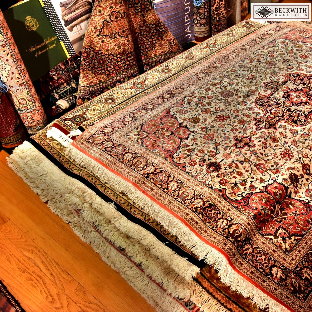 Spectacular stack of carpets on the floor, surrounded by rolls of similar carpets inside Beckwith Galleries' Ottawa showroom.