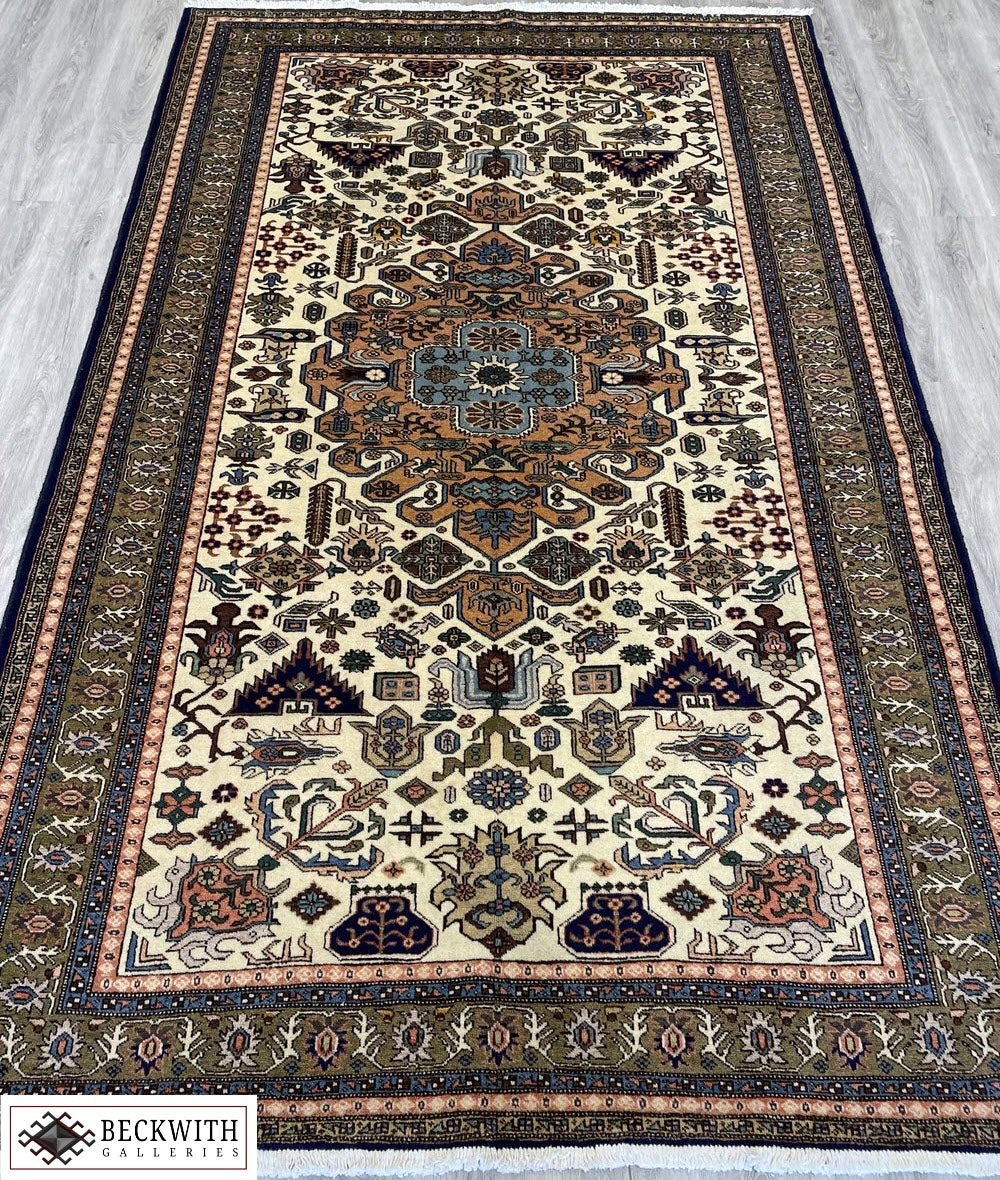 A hand-knotted wool on cotton foundation Ardebil rug with a floral and geometric pattern in beige, brown, and multicolor.