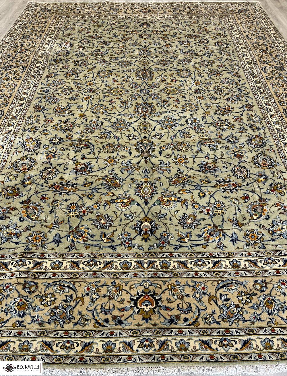 A hand knotted wool rug with a floral and geometric pattern in beige, brown, and gray hues.