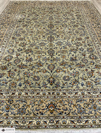 A hand knotted wool rug with a floral and geometric pattern in beige, brown, and gray hues.
