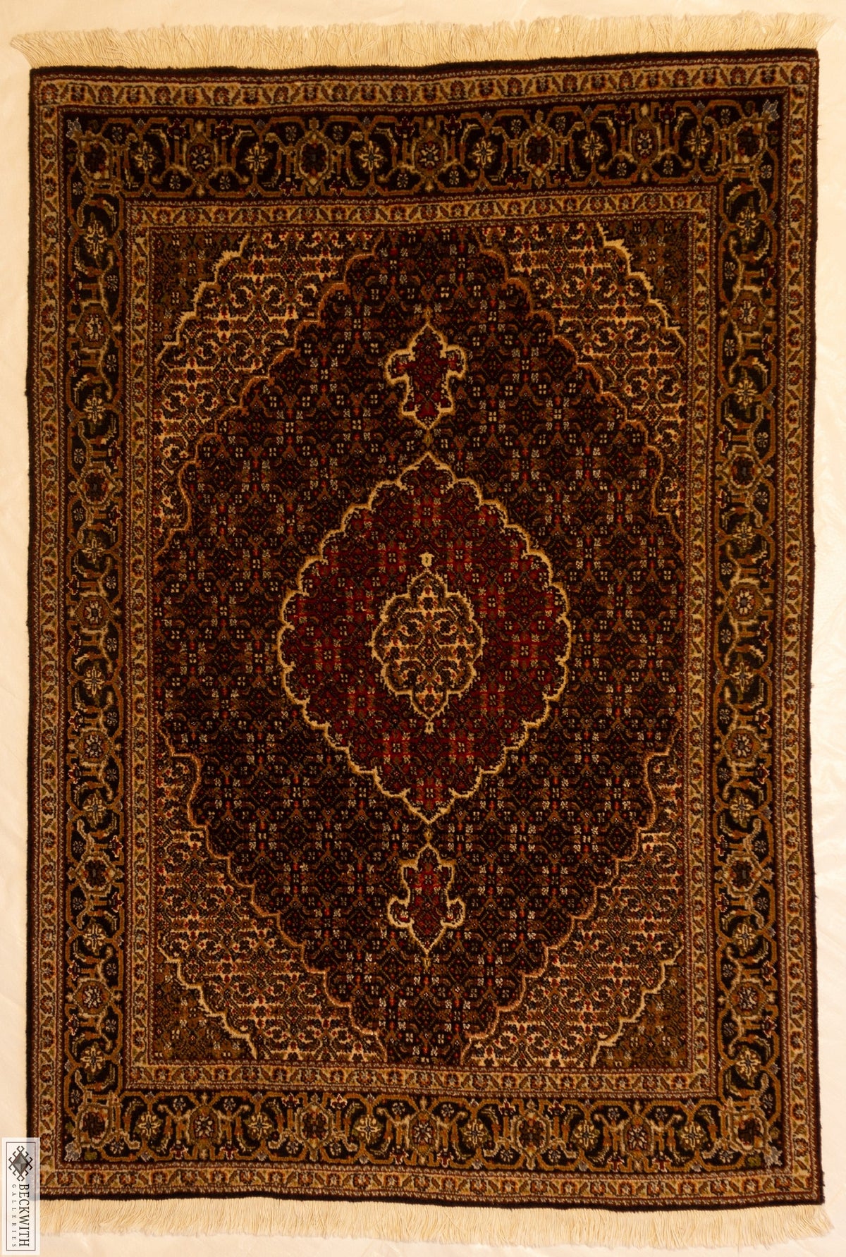 A rectangular traditional Tabriz rug with a geometric and floral pattern in brown, black, gold, and cream colors.